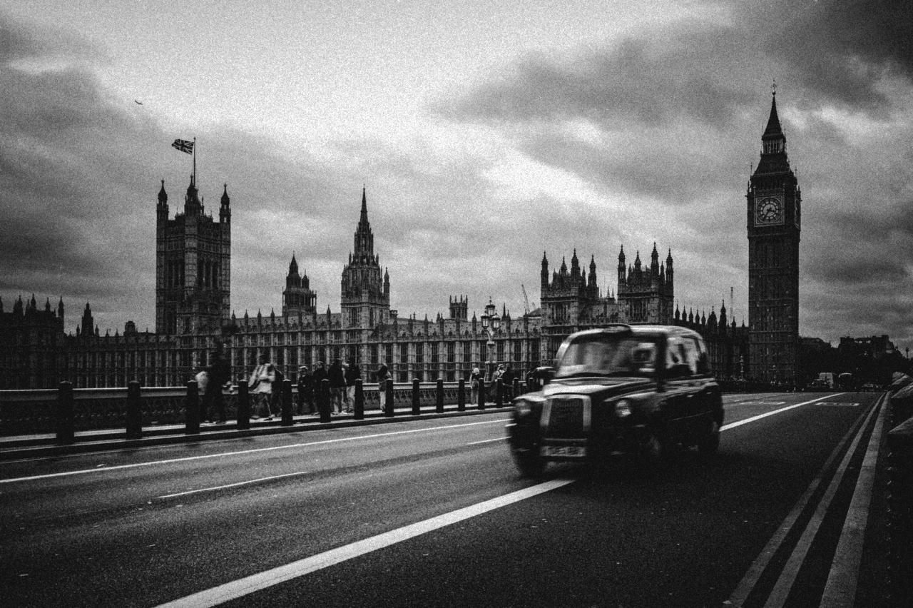 Black cab rushing past the Houses of Parliament